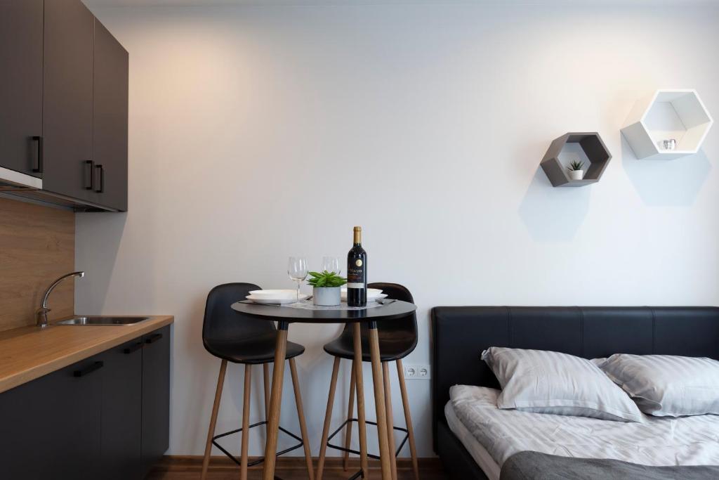 a small table with two chairs next to a bed at Oak house apartments in Kaunas