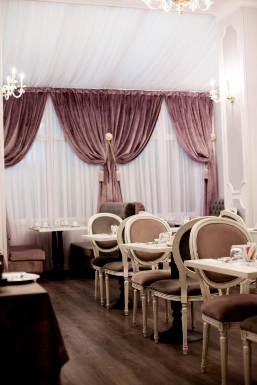 a dining room with tables and chairs and curtains at Hôtel restaurant Oasis in Nice