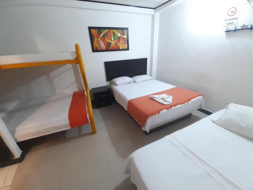 A bed or beds in a room at Hotel Arcoiris Girardot