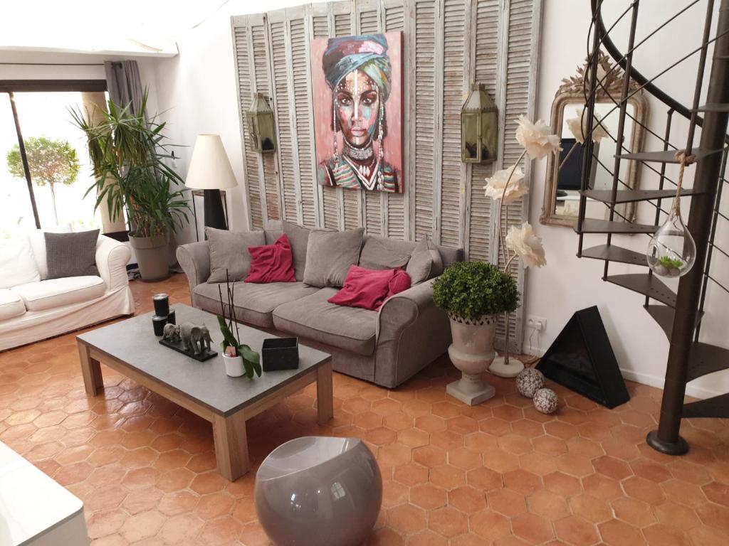 uma sala de estar com um sofá e uma mesa em Loft avec spa Lourmarin em Lourmarin