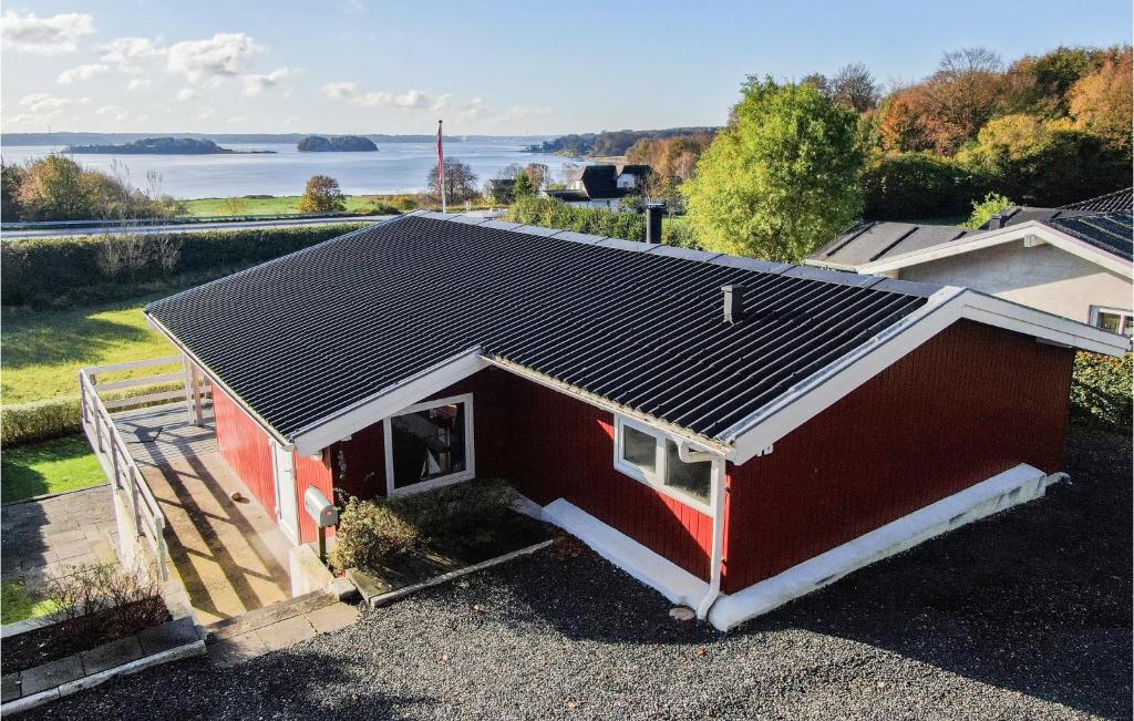 una casa roja con un techo negro encima en Cozy Home In Krus With House Sea View, en Kruså
