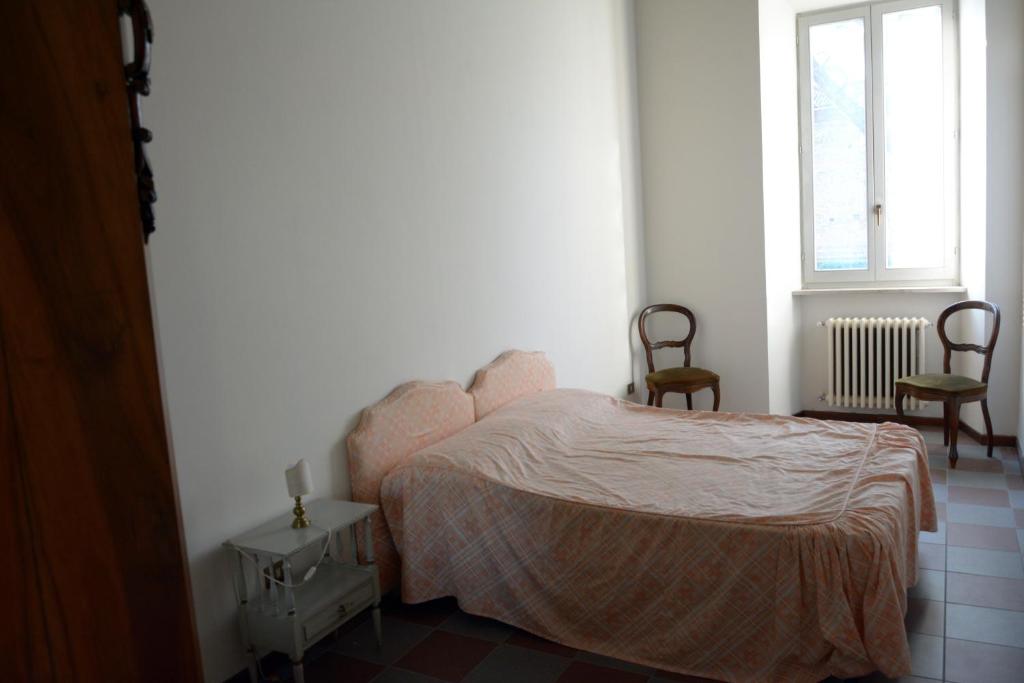 1 dormitorio con 1 cama, 2 sillas y ventana en Garibaldi residence in Rieti, en Rieti