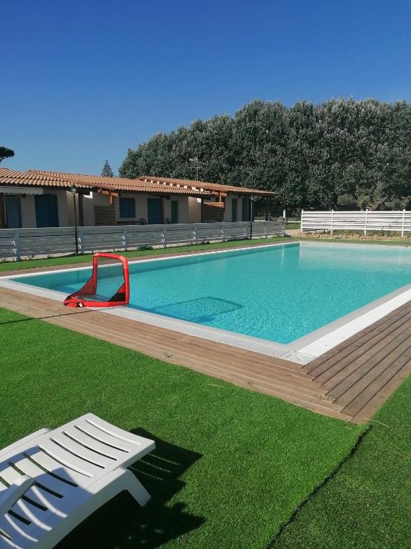 uma grande piscina com um banco num quintal em agriturismo oca giuliva em Lido dei Pini