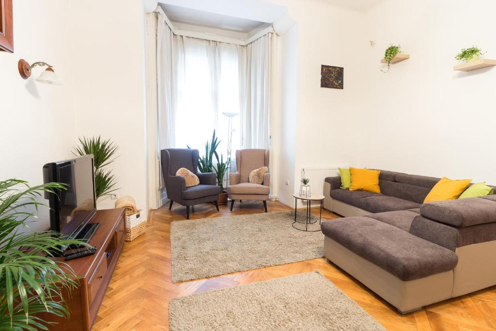 a living room with a couch and a tv at Szasz Buda Villa Apartment next to Buda Castle district in Budapest