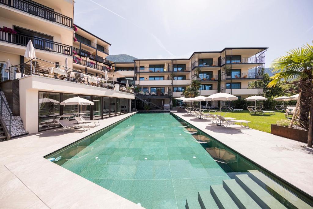 a swimming pool in front of a building at Hotel Der Weinmesser in Schenna