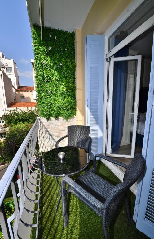 a patio with two chairs and a table on a balcony at Hôtel de Provence in Cannes