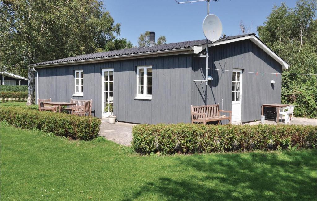 um edifício azul com dois bancos à frente em Beautiful Home In Sydals With Wifi em Skovby