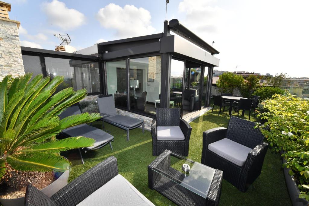 a rooftop patio with chairs and a table at Hôtel de Provence in Cannes