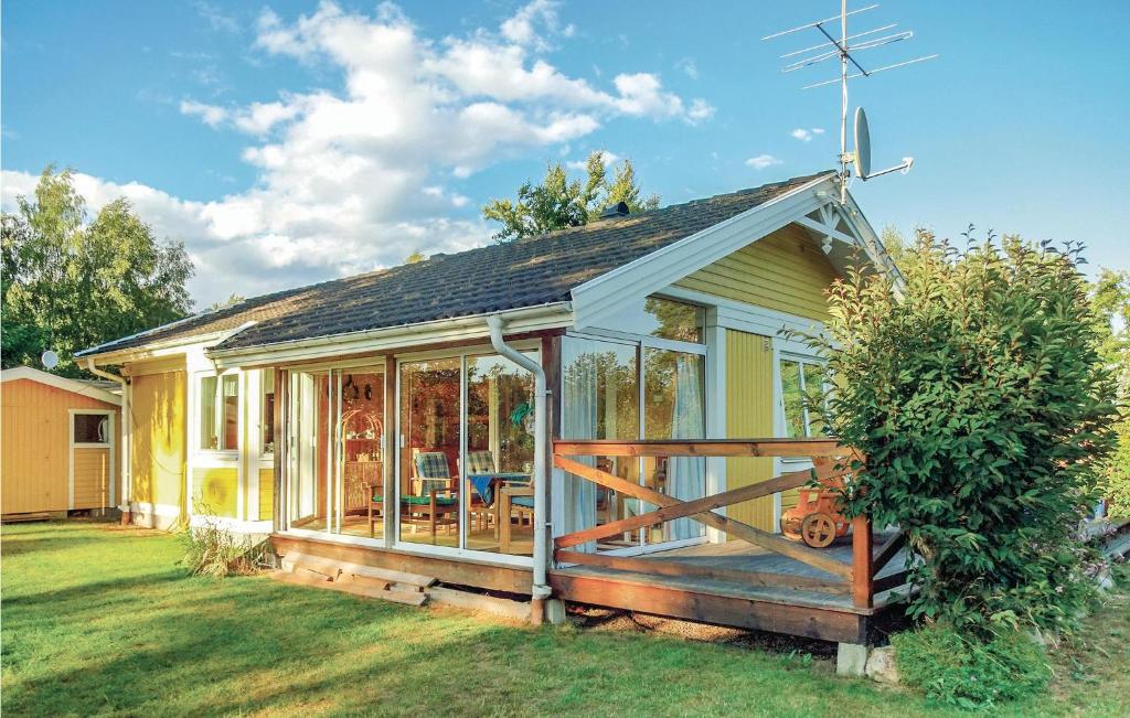 een klein huis met een veranda en een terras bij Stunning Home In Tors-slvesborg With Kitchen in Torsö