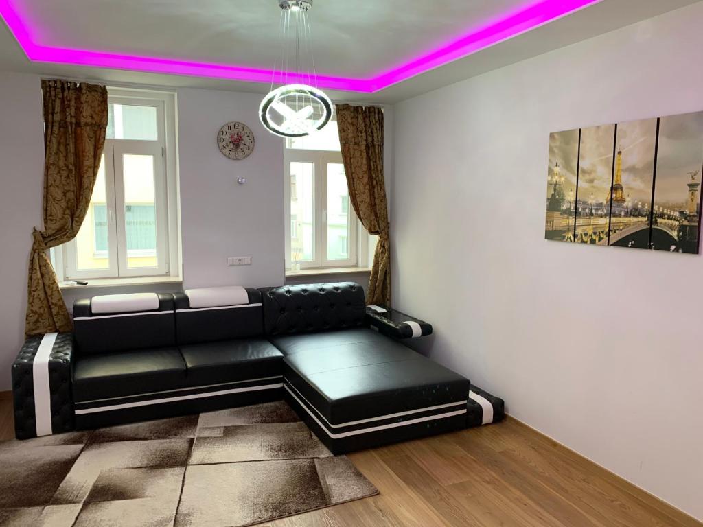 a living room with a black couch and pink lighting at Colony Apartments in Vienna