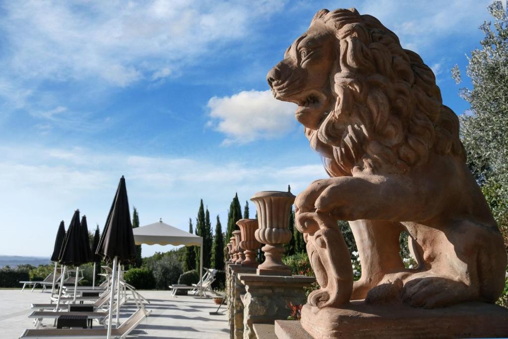 posąg lwa siedzącego na dziedzińcu w obiekcie La Vecchia Sassa w mieście Montaione