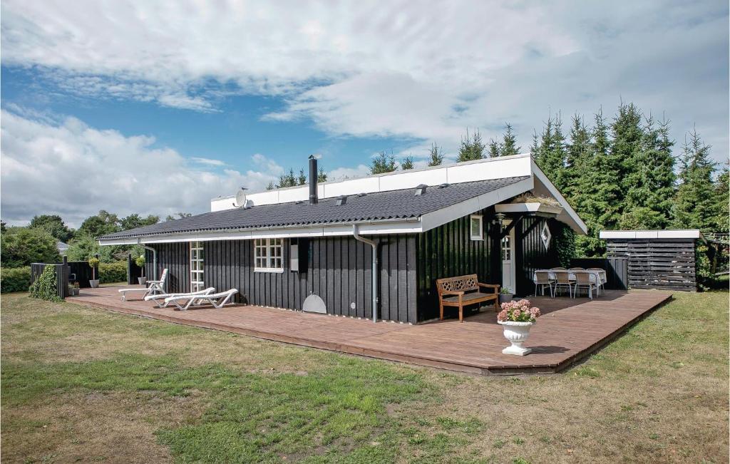 HaslevgårdeにあるAwesome Home In Hadsund With 4 Bedrooms, Sauna And Wifiの木製のデッキが目の前にある黒い建物