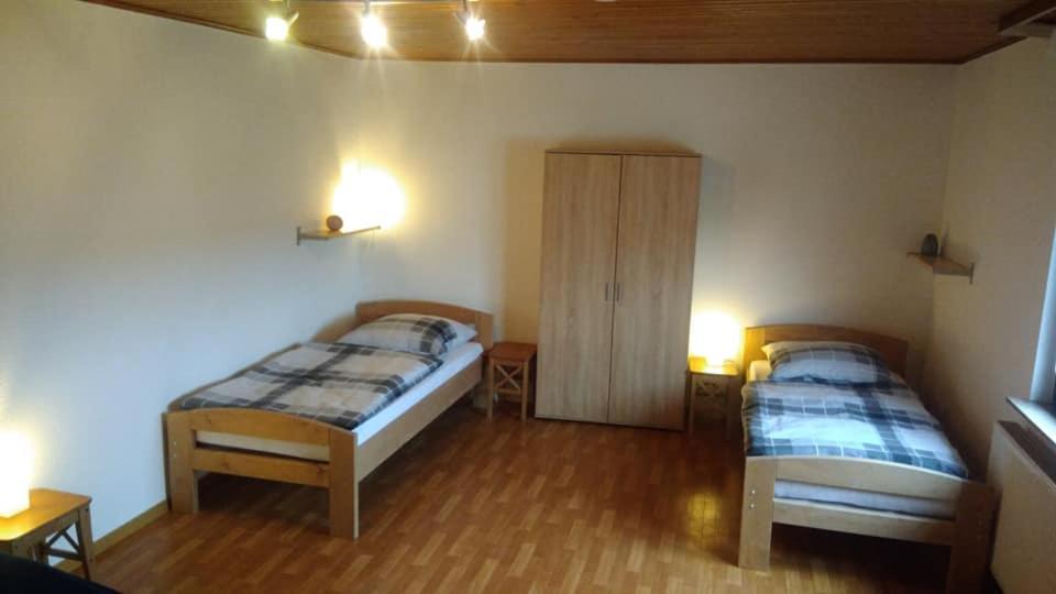 a bedroom with two beds and a cabinet in it at "Klein und Fein"-Monteurzimmer Pohlheim in Pohlheim