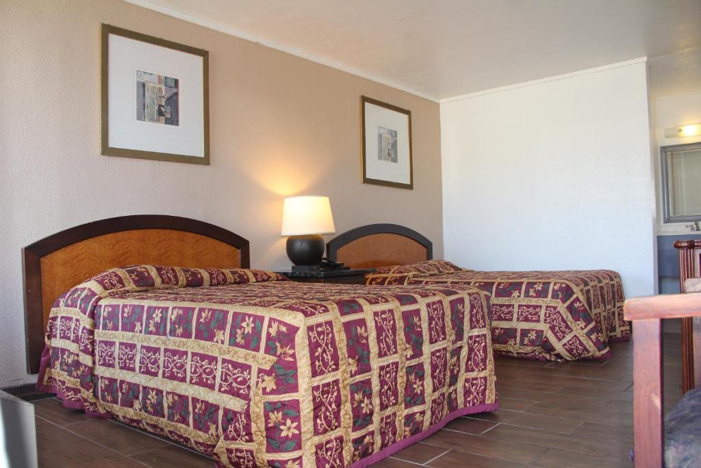 Postel nebo postele na pokoji v ubytování LoneStar Inn and Suites
