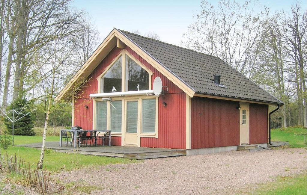 un hangar rouge avec une table et des chaises sur une terrasse dans l'établissement Awesome Home In Bolms With Ethernet Internet, à Bolmsö