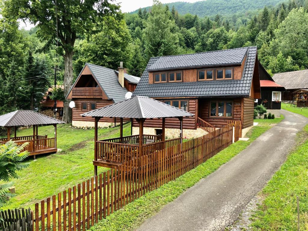 ein Holzhaus mit einem Zaun davor in der Unterkunft Viktória- neakceptujeme mladé partie in Terchová
