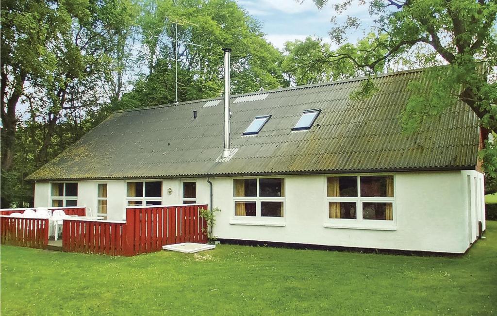 een wit huis met een rood hek in een tuin bij Hjrnet in Sindal