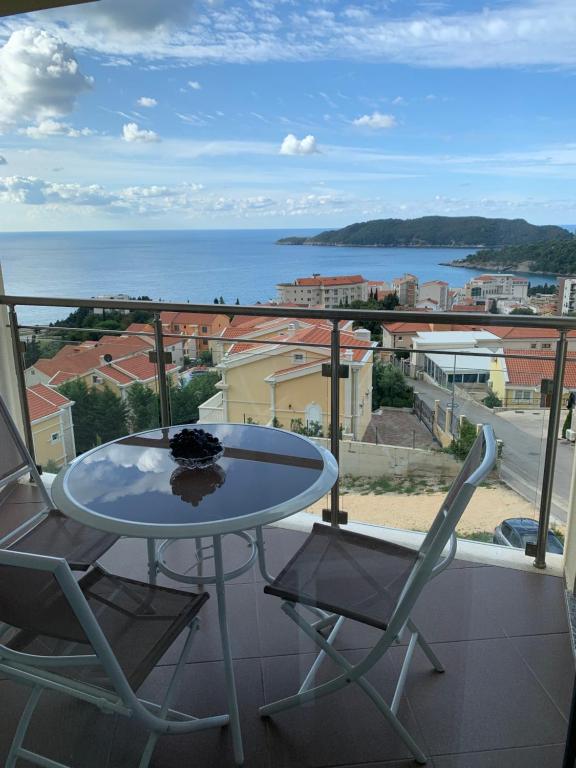 a table and chairs on a balcony with a view of the ocean at Ive Lole Ribara 38 in Becici