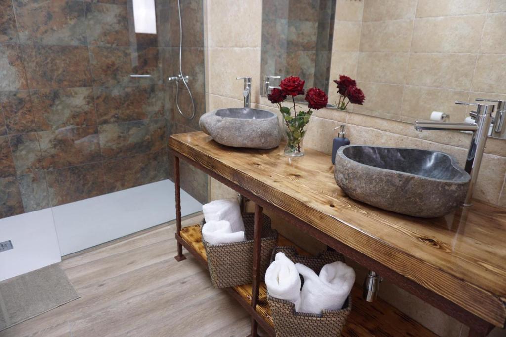 - une salle de bains avec deux lavabos sur un comptoir en bois dans l'établissement Casa La Solana, à Bolaños de Campos