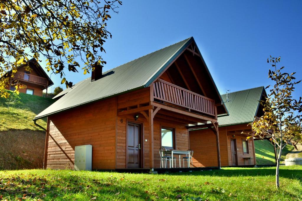 a large wooden house with a metal roof at Domki Za Górą in Jazowsko