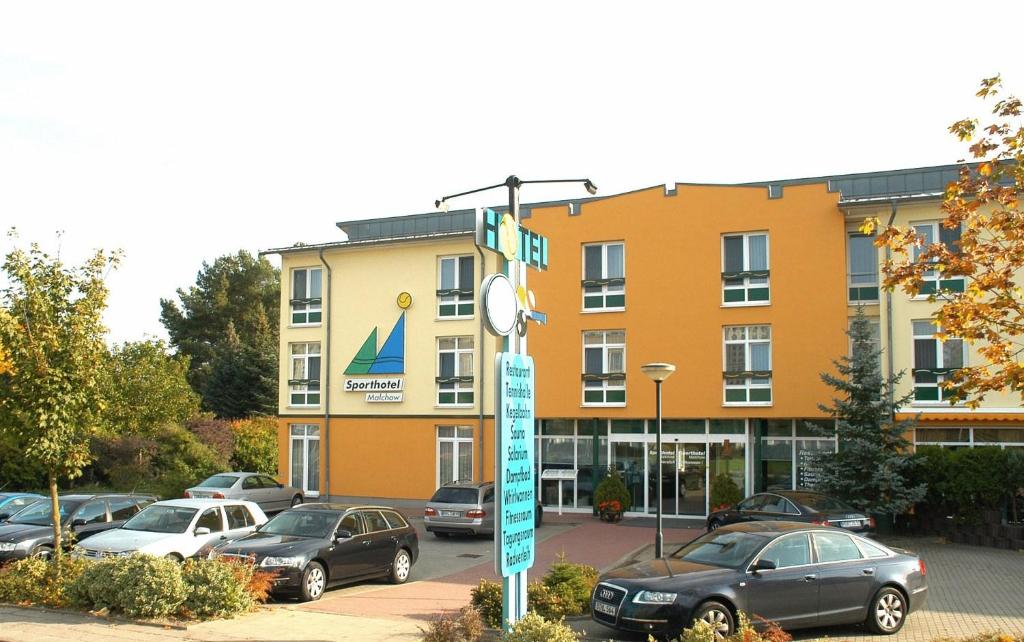 馬爾喬的住宿－Sporthotel Malchow Hotel Garni HP ist möglich，停车场内有车辆的建筑物