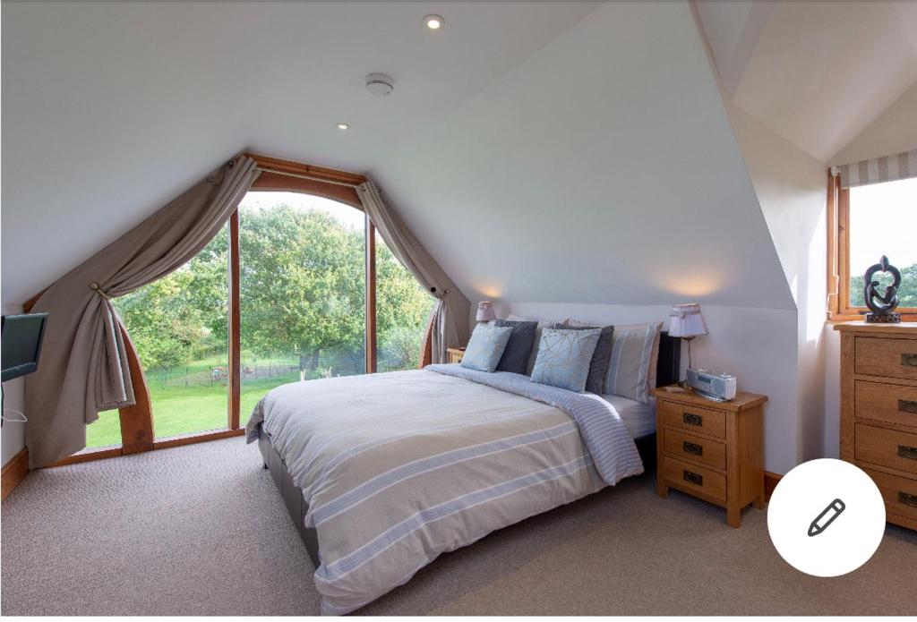 1 dormitorio con cama y ventana grande en The Chalet Somerset en Angersleigh