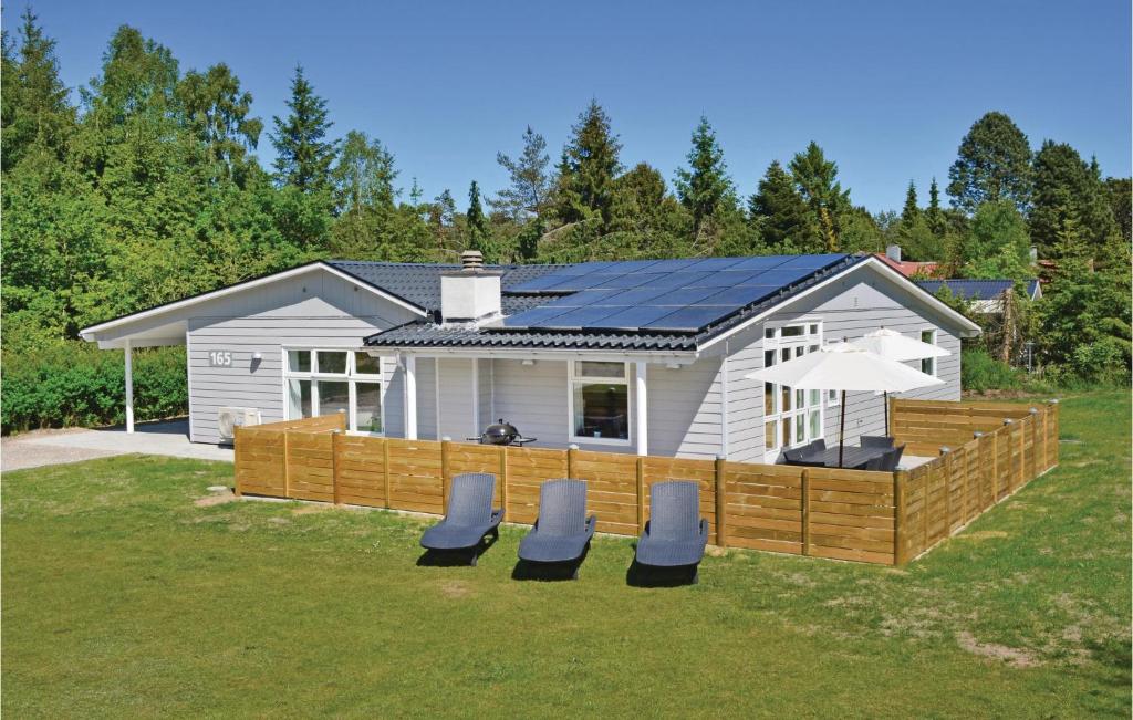 une petite maison avec une terrasse et des chaises dans la cour dans l'établissement Beautiful Home In Ebeltoft With Kitchen, à Øksenmølle