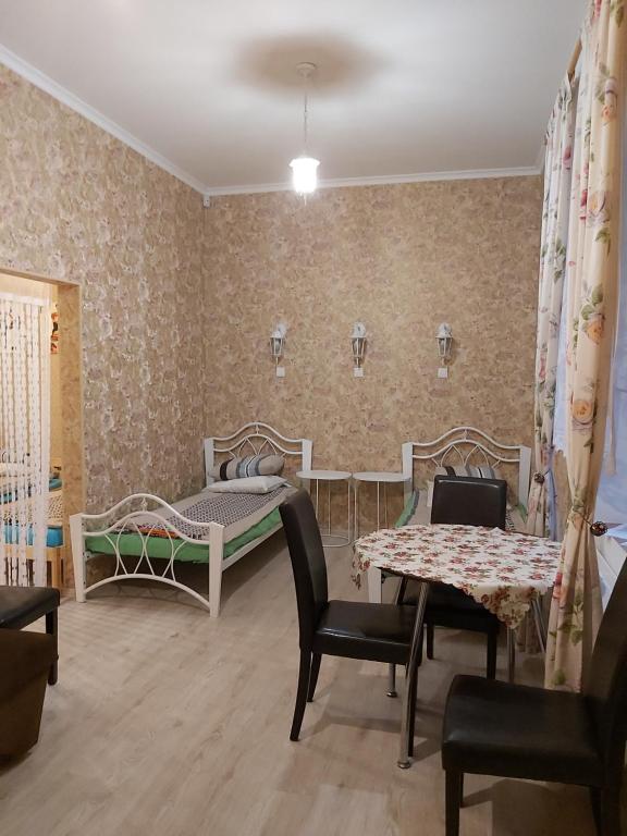 a room with two beds and a table and chairs at Sofija apartamenti in Daugavpils