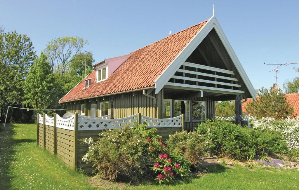 グドイェムにあるBeautiful Home In Gudhjem With Kitchenの庭の花と柵のある家