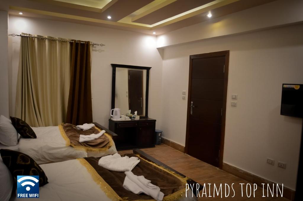 a hotel room with two beds with towels on them at Pyramids Top Inn in Cairo