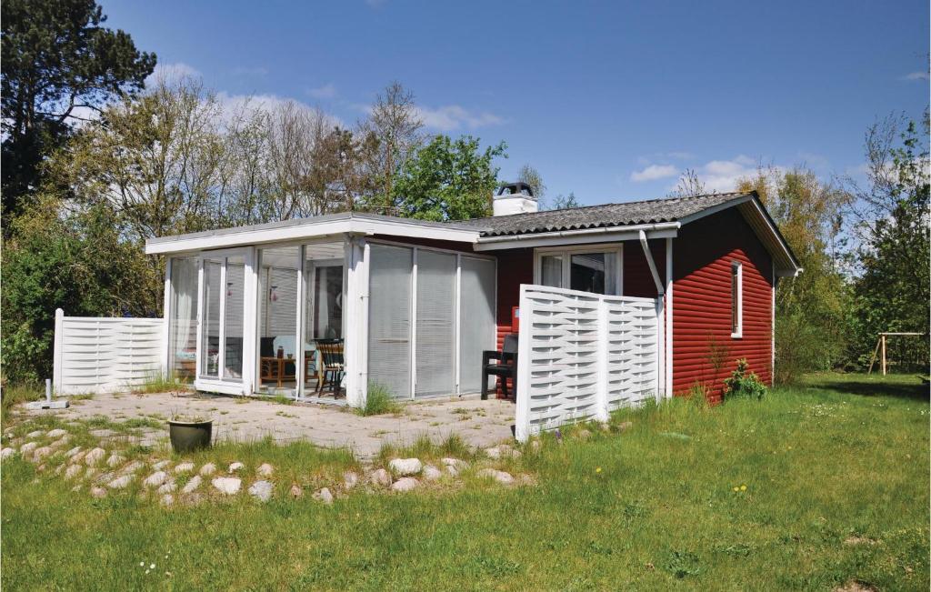 a small red and white house in a yard at Holiday Home Strandholmen Millinge V in Millinge