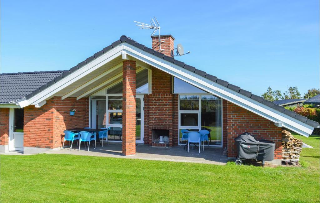 een stenen huis met tafels en stoelen in een tuin bij Stunning Home In Hadsund With Kitchen in Haslevgårde