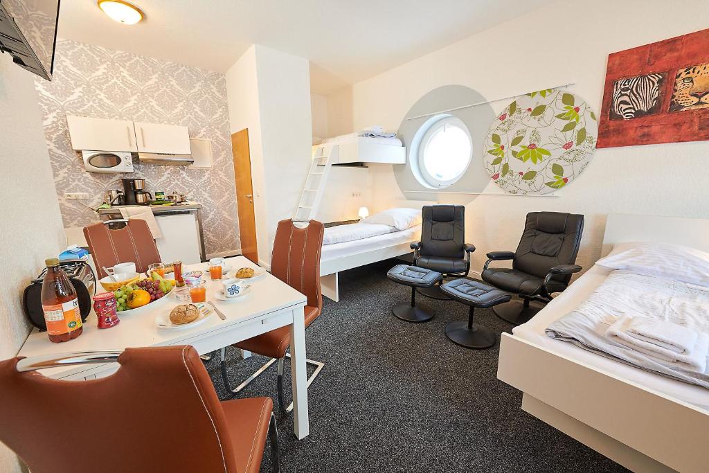 Habitación pequeña con cama, mesa y sillas en Aparthotel Wilma, en Bremen