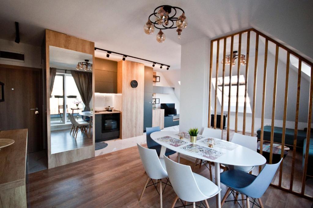 a dining room and living room with a white table and chairs at Apartment City View in Sofia
