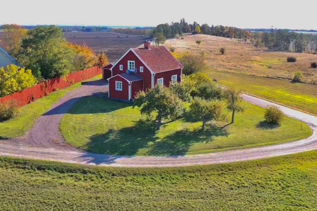 une vue aérienne sur une maison rouge sur un champ vert dans l'établissement STUBBET - Charming - Newly Remade Villa, à Vadstena