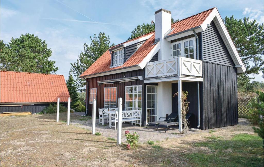 a black and white house with a porch at Two-Bedroom Holiday Home In Ebeltoft in Ebeltoft