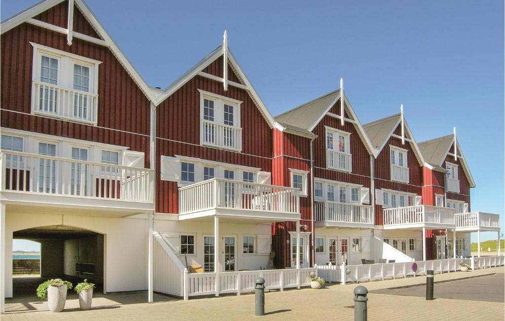 BagenkopにあるAmazing Apartment In Bagenkop With 3 Bedrooms And Saunaの白いバルコニー付きの大きな赤い建物