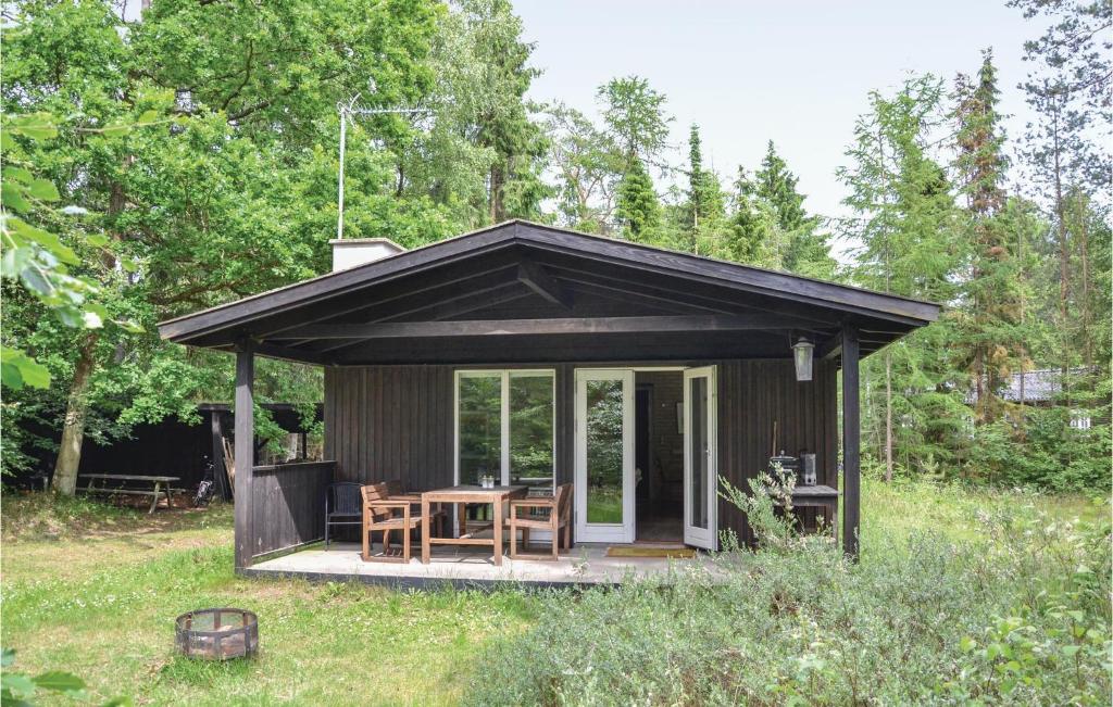 a small cabin with a table and chairs in a field at 2 Bedroom Stunning Home In Frederiksvrk in Liseleje