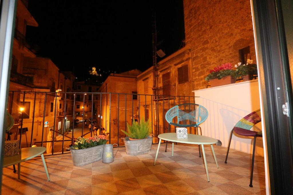 a balcony with chairs and a table and a fence at Torre's Camere & caffè in Monreale