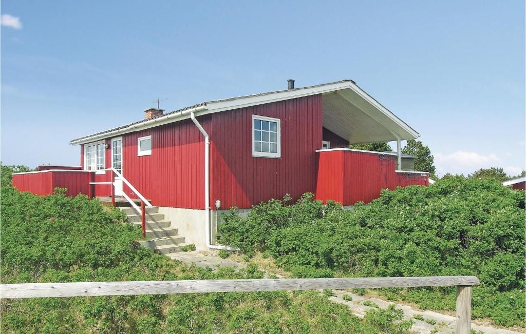 ein rotes Gebäude auf einem Hügel mit Treppen, die dorthin führen. in der Unterkunft Hega in Fanø