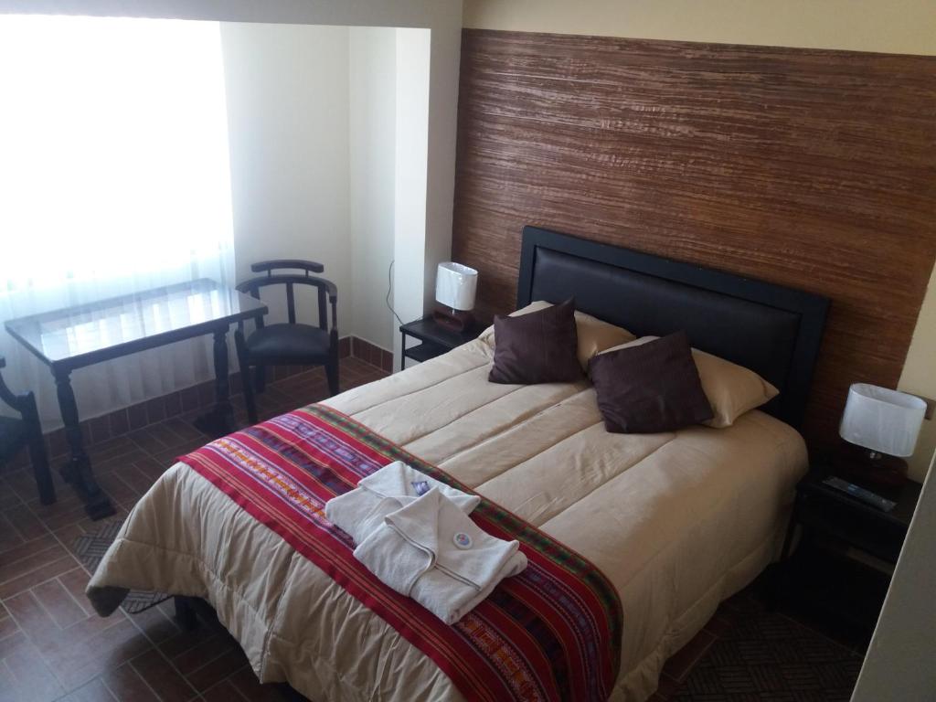 a bedroom with a large bed with a wooden headboard at Hostal Jerian in Uyuni