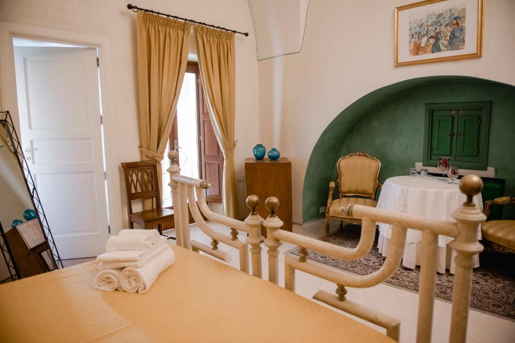 Habitación con cama y mesa con toallas en Corte Baldi, en Galatina