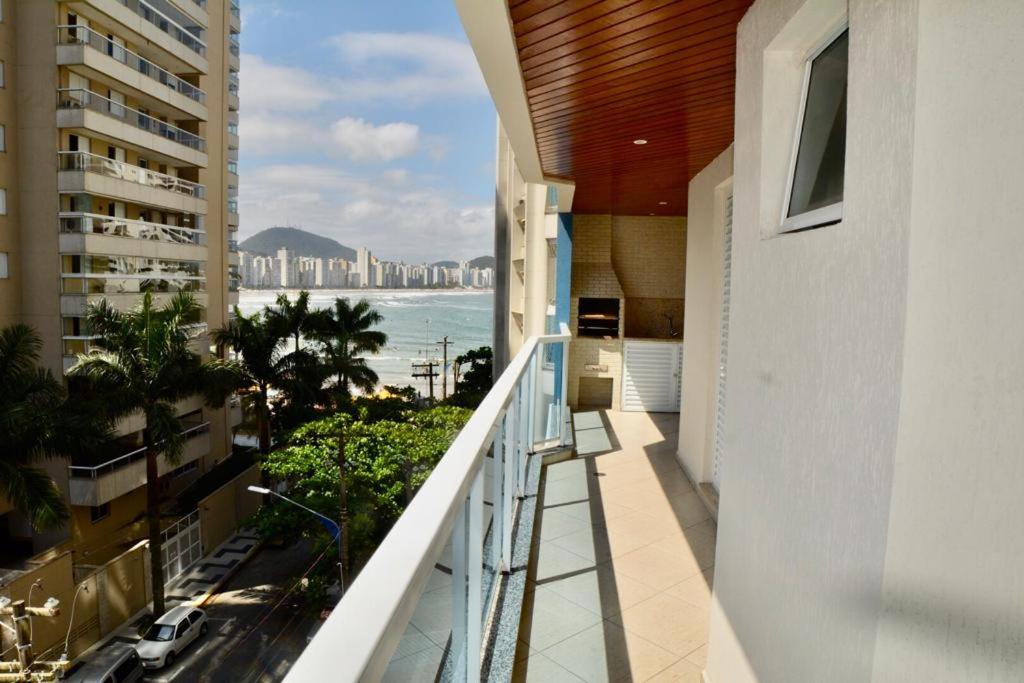 einen Balkon mit Blick auf das Meer und die Gebäude in der Unterkunft Neto & Costa in Guarujá