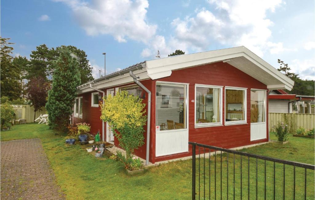 a red house with a white door in a yard at Beautiful Home In Karrebksminde With 2 Bedrooms And Wifi in Karrebæksminde