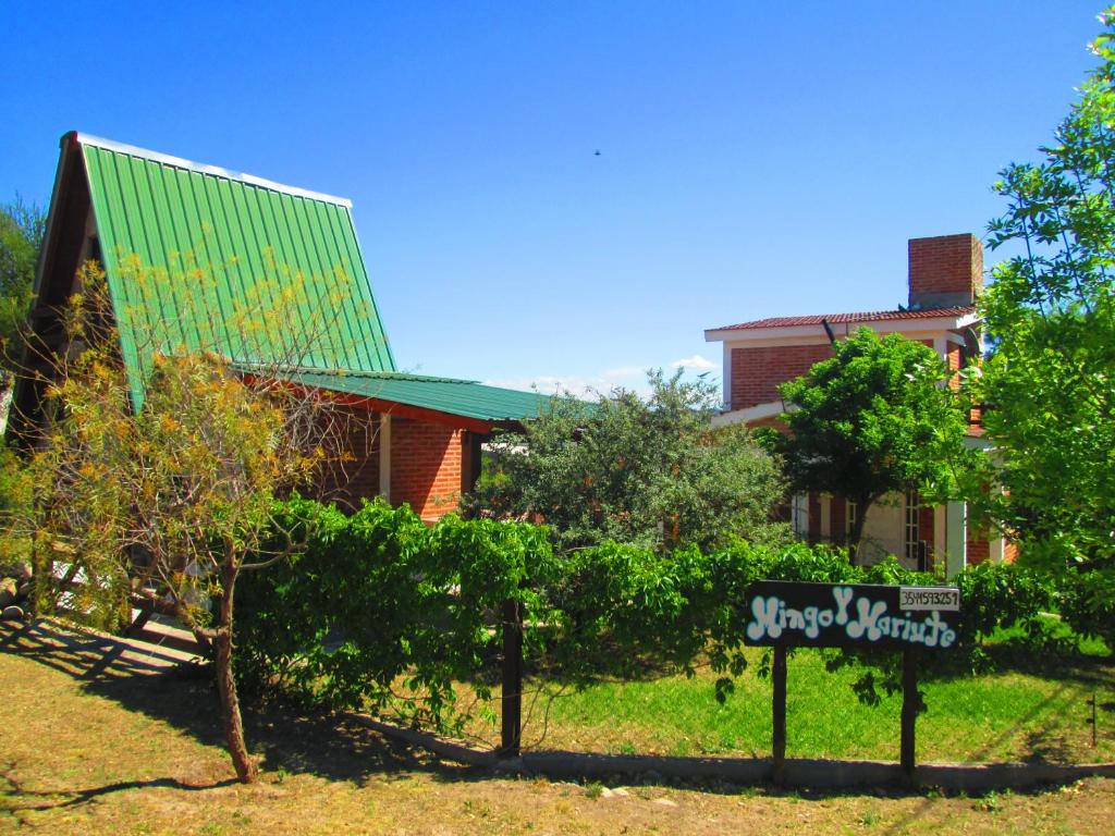 een huis met een bord voor een tuin bij Cabañas Mingo y Mariute in Mina Clavero