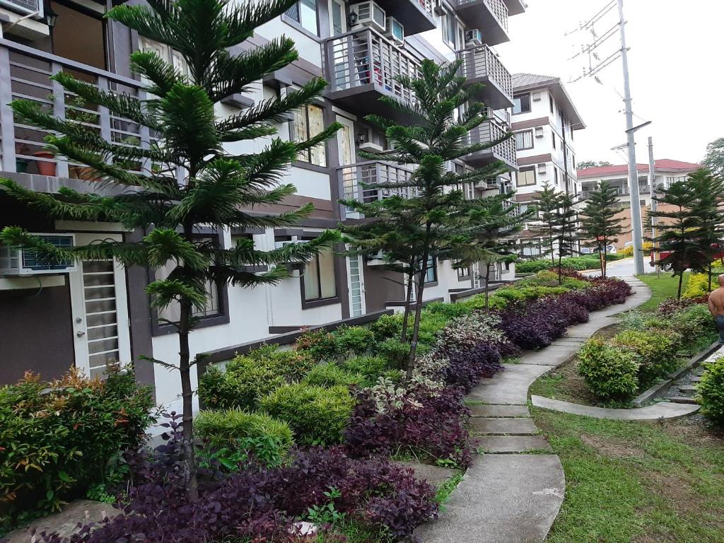 un bâtiment avec des arbres et des plantes devant lui dans l'établissement Condo eLgimikero, à Manille