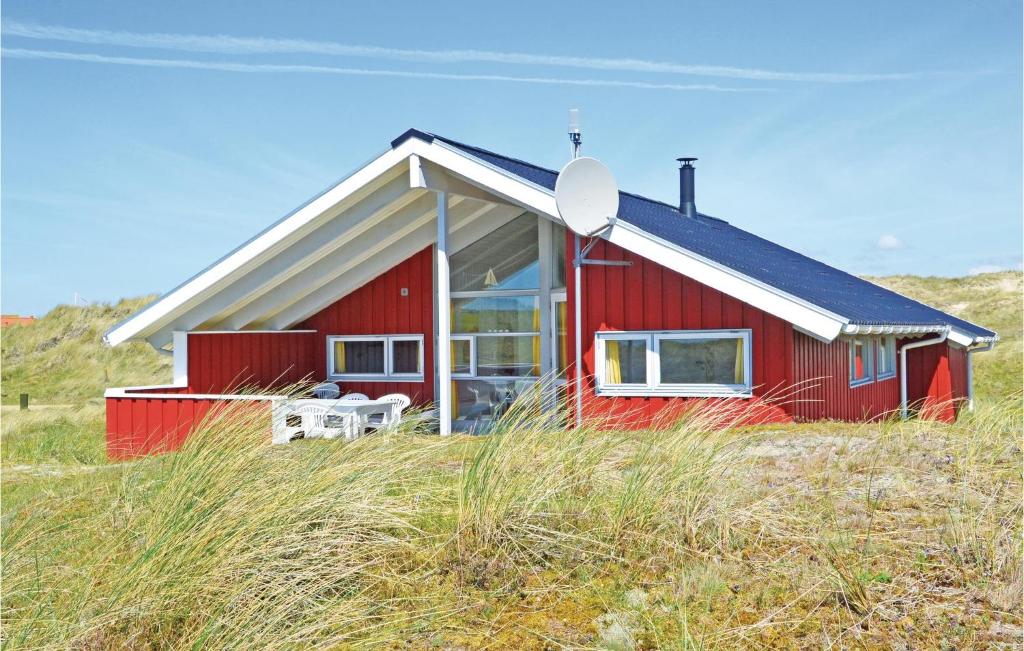 uma casa vermelha sentada em cima de um campo em Amazing Home In Fan With Sauna em Sønderho