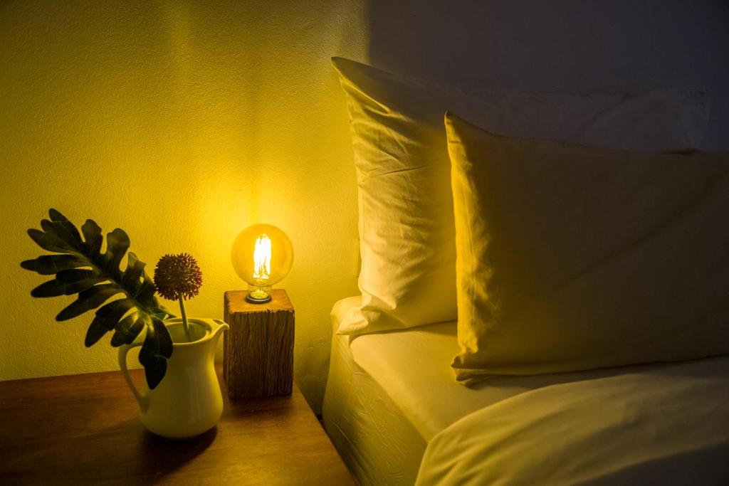 a bed with a vase with a plant and a lamp at Big Tree Boutique Hotel in Ko Tao
