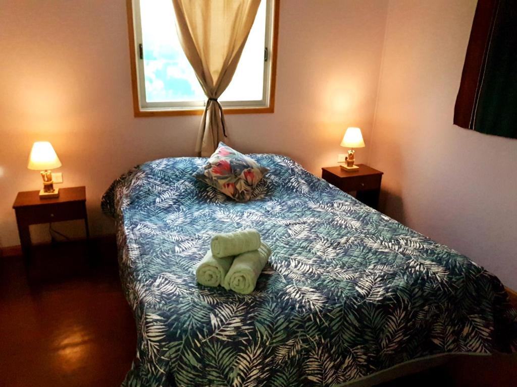 a bedroom with two towels on a bed with two lamps at Uka Vaikava in Hanga Roa