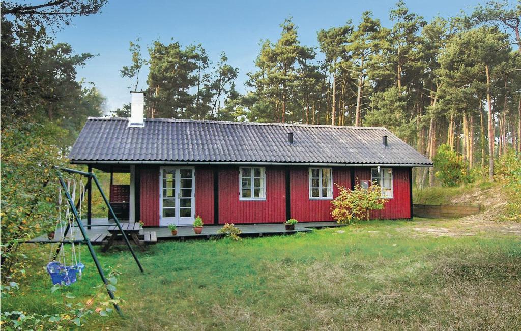 a small red house in the middle of a field at 3 Bedroom Amazing Home In Aakirkeby in Vester Sømarken